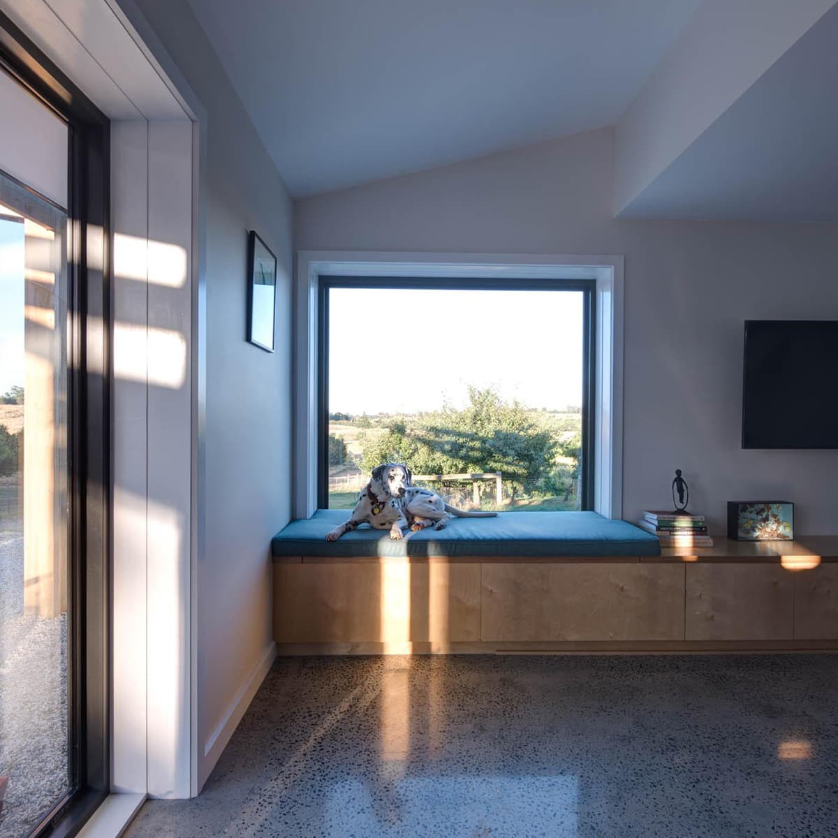 Deep timber-reveal window framing the rural outlook